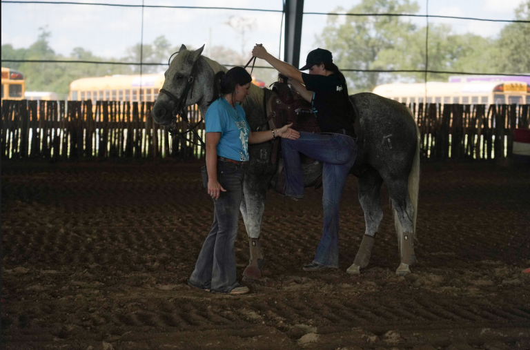 Stacey Martin explains the horse dismount in goat tying to this student.